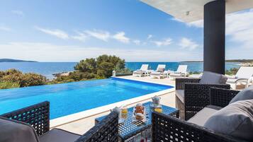Outdoor pool, an infinity pool, pool loungers