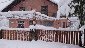 Un edificio cubierto de nieve con fachada roja y techo inclinado.