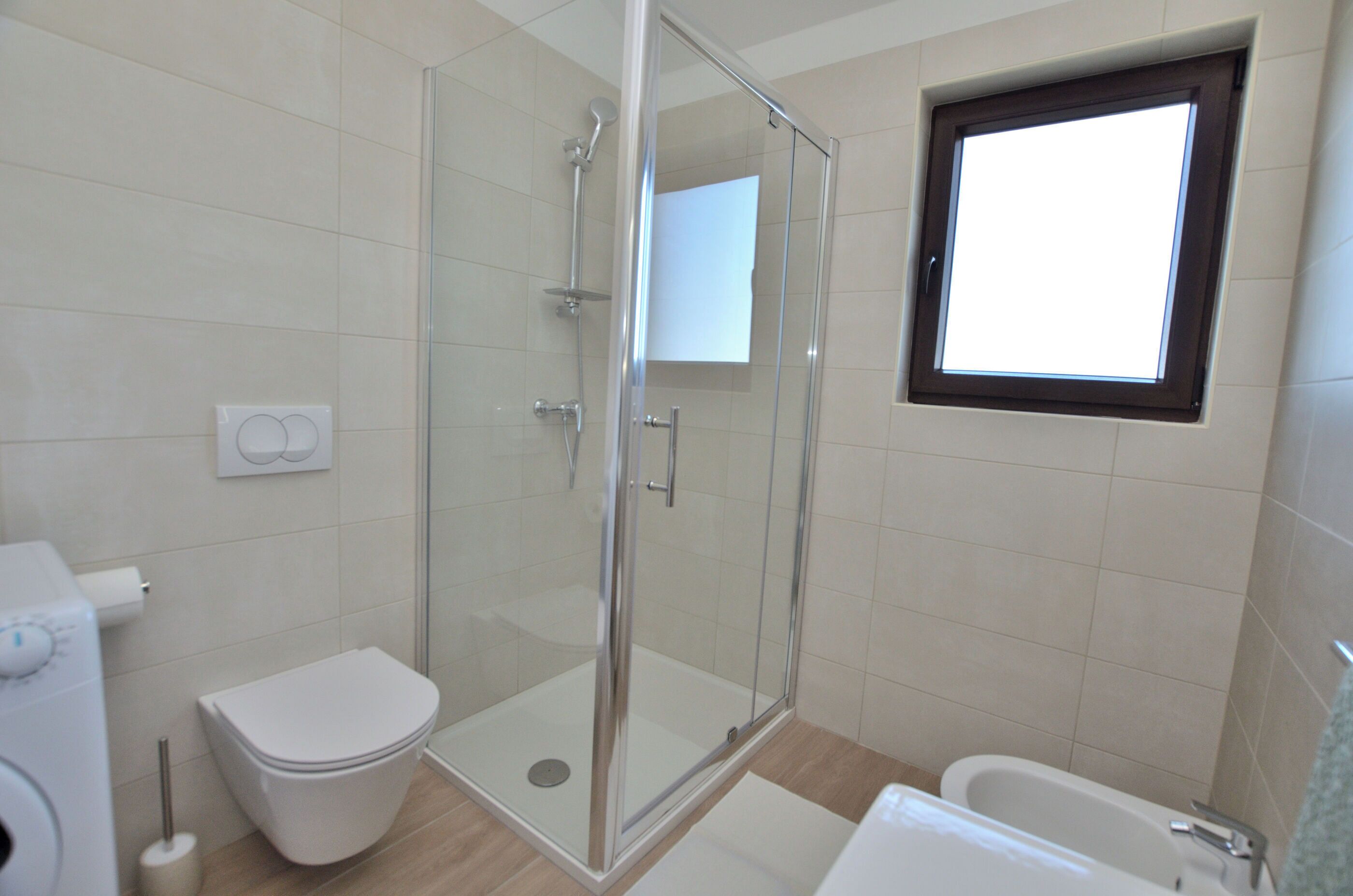 Une salle de bain avec une douche à parois de verre, des toilettes et une baignoire.