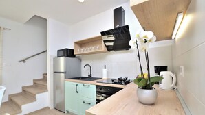 A modern kitchen with a built-in oven, a stainless steel refrigerator, and a wooden countertop. - House Danci (Vizinada)