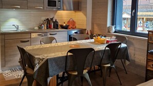 Une cuisine moderne avec une table à manger, des chaises et une fenêtre donnant sur un immeuble.