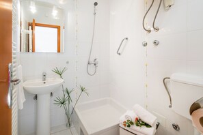 A modern bathroom with a white sink, a bathtub, and a shower with a handheld showerhead. - Apartments Villa Vallum (Bol)