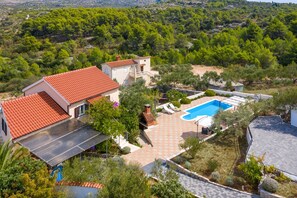Una casa con piscina, paneles solares y jardín.