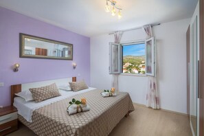 Une chambre à coucher avec un lit, une fenêtre donnant sur un beau paysage, un miroir et un luminaire.