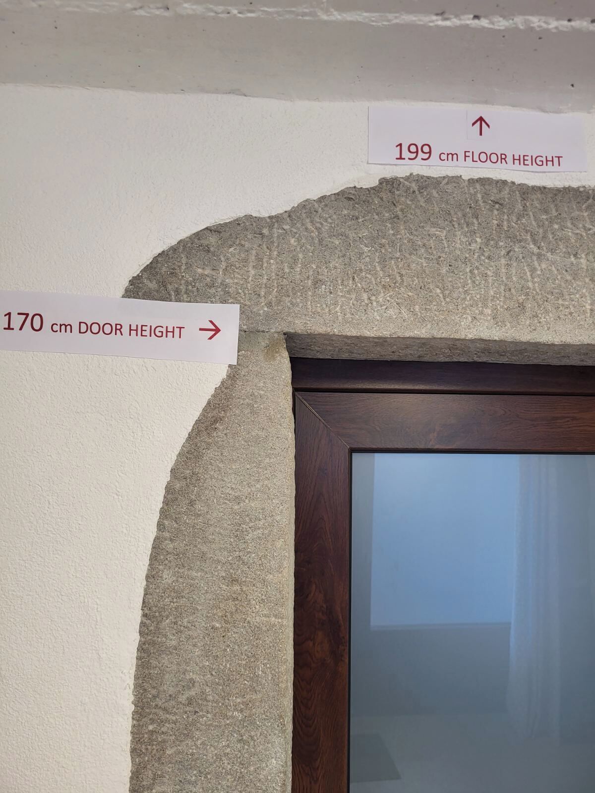 A door with a height sign of 170 cm and a floor height sign of 199 cm.