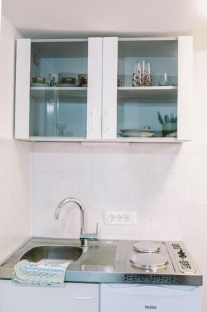 A kitchen with white cabinets, a stainless steel sink, and a built-in stove. - Apartment Balidur (Buzet)