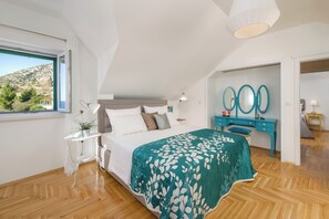 A bedroom with a bed, bedside table, and a view of the outdoors. - Villa Lipa Dora (Bol)