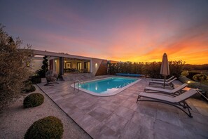 Una piscina al aire libre, una piscina climatizada, sombrillas
