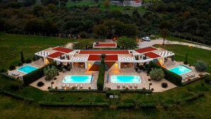 A large, modern villa with multiple swimming pools, a covered patio, and a well-maintained garden. - Villa Royal Green Three (Policnik)