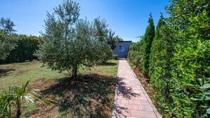 A pathway leading to a building surrounded by lush greenery and trees. - House Peroj (Vodnjan)