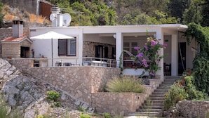 A modern house with a stone facade, a covered outdoor seating area, and a staircase leading to the entrance. - House Peacefull Relax (Jelsa)