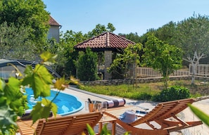 A pool area with lounge chairs, a hot tub, and a gazebo. - Villa Rita (Sveti Filip i Jakov)