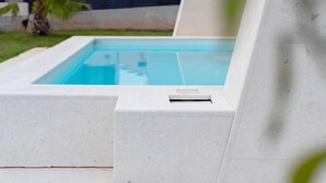 Une piscine avec un bord en béton et un drain.