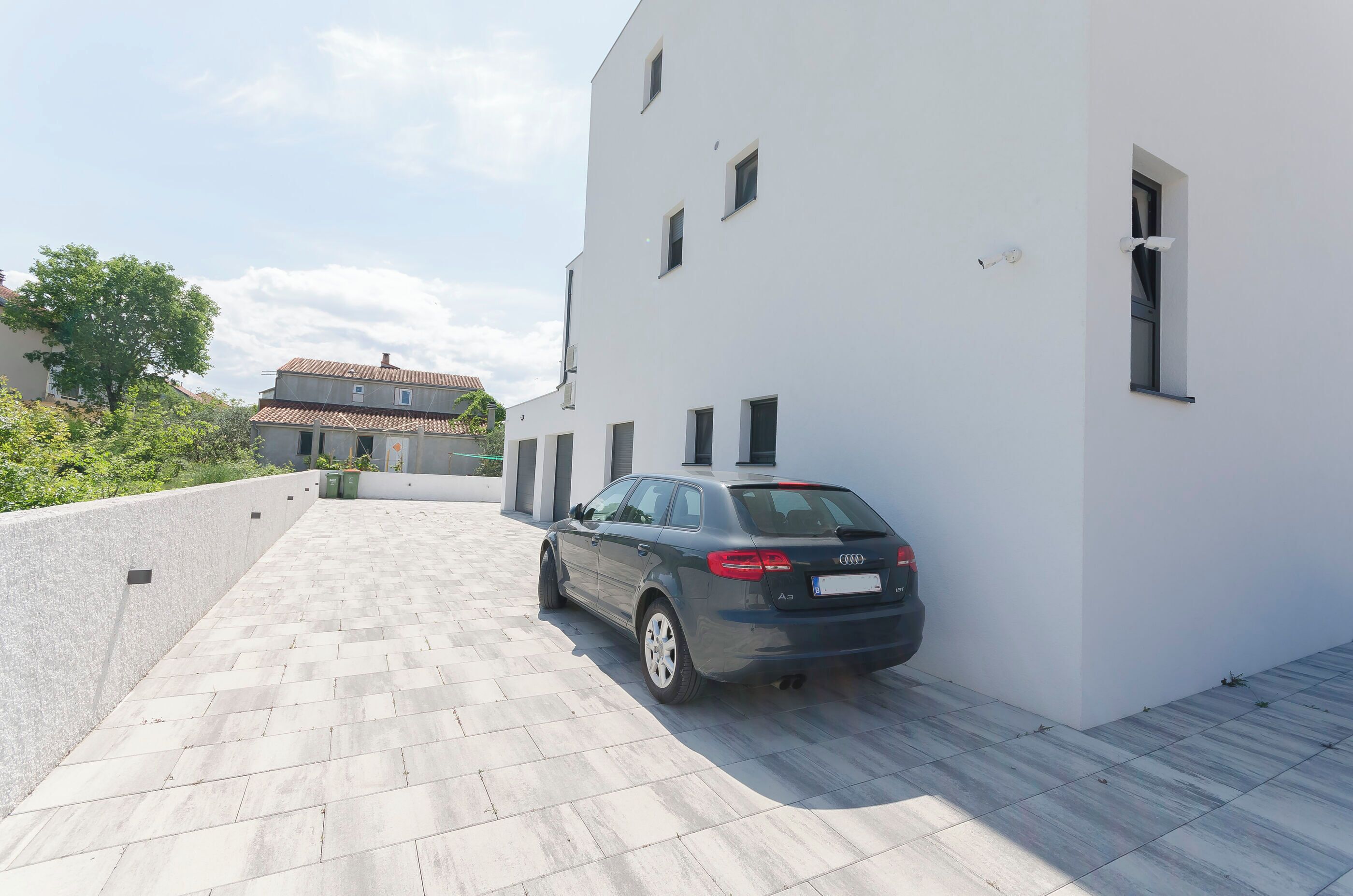 Um edifício moderno com um carro estacionado na frente.