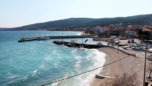 A coastal town with a pier, boats, and a beach. - Apartment Iskra (Split)