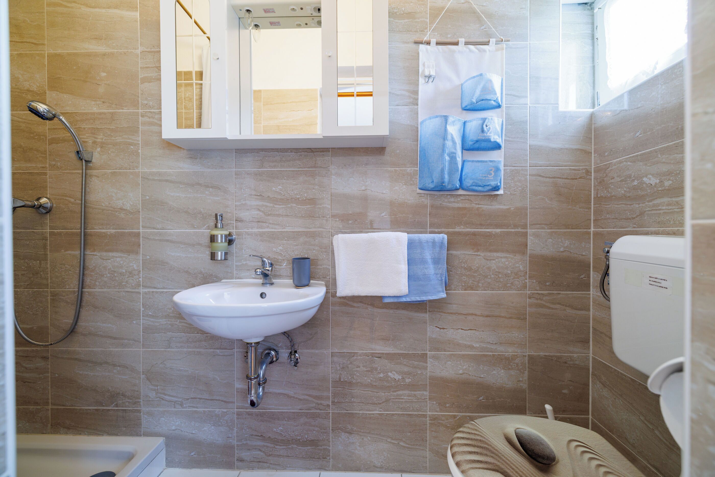 A bathroom with a sink, mirror, shower, and toilet.