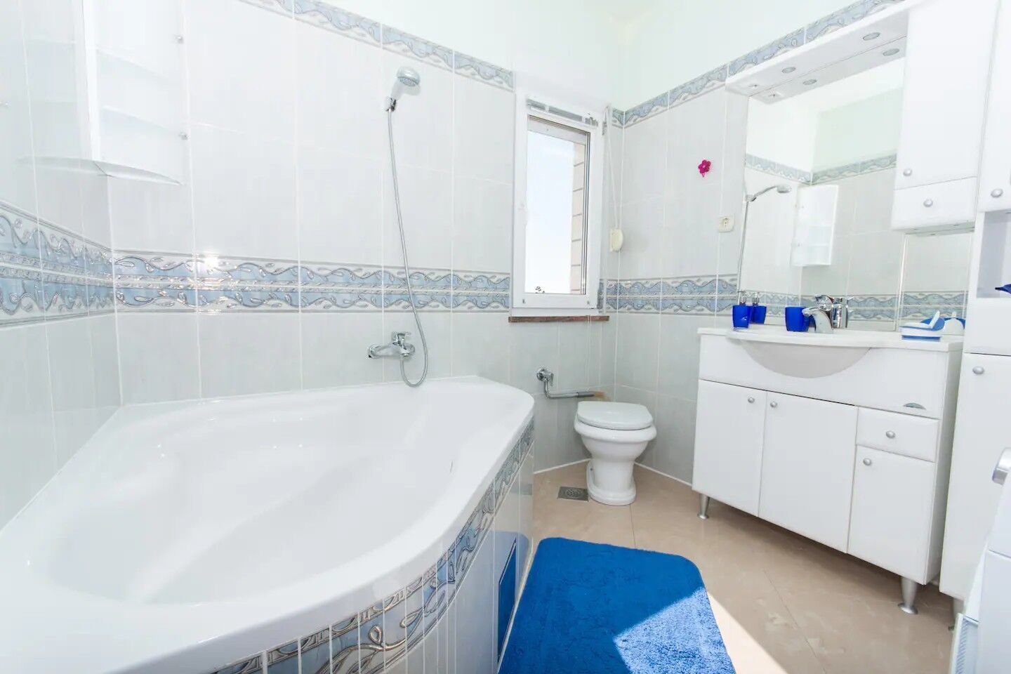 Een badkamer met een bad, toilet en wastafel.