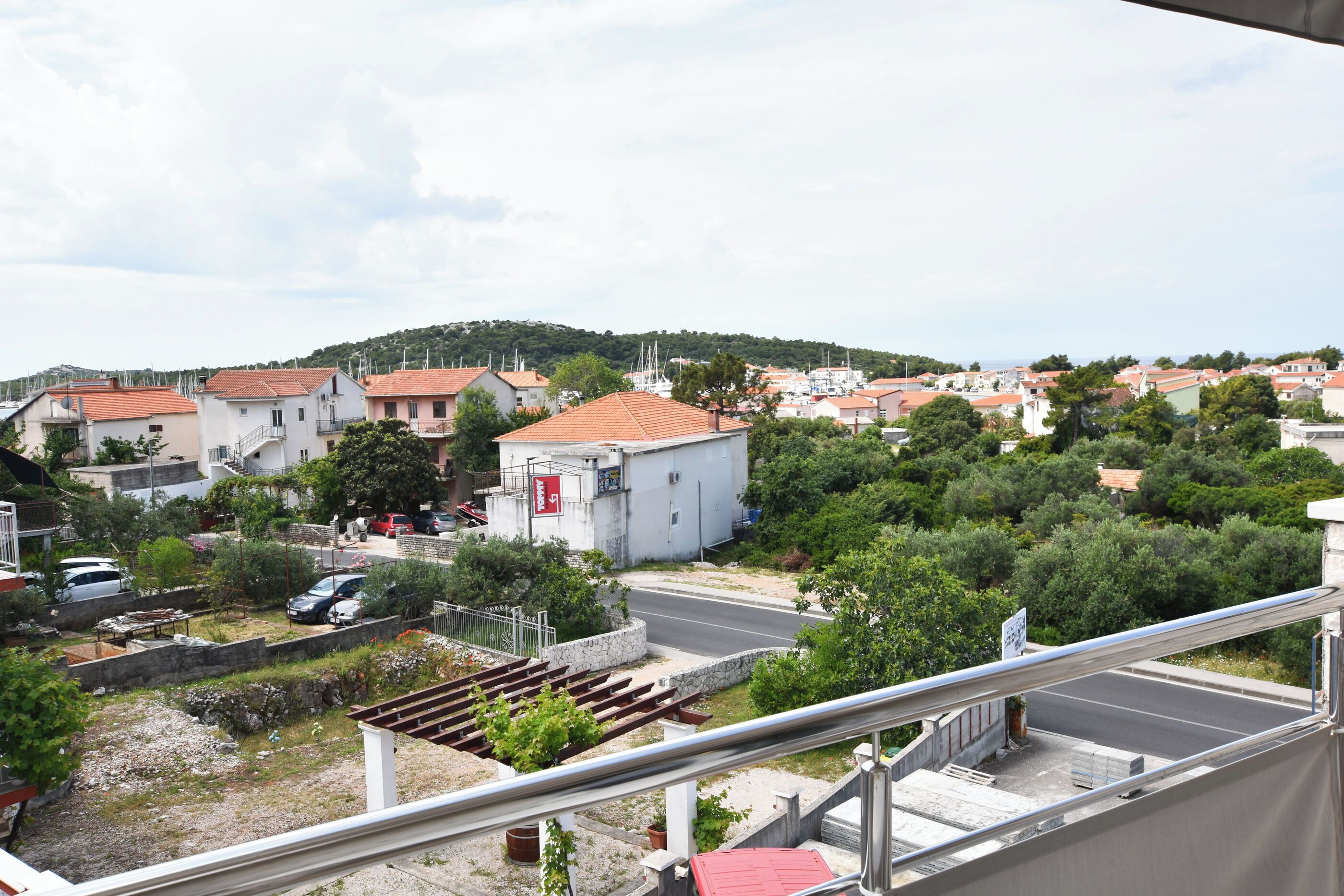 A residential area with houses, a road, and a hill in the background.