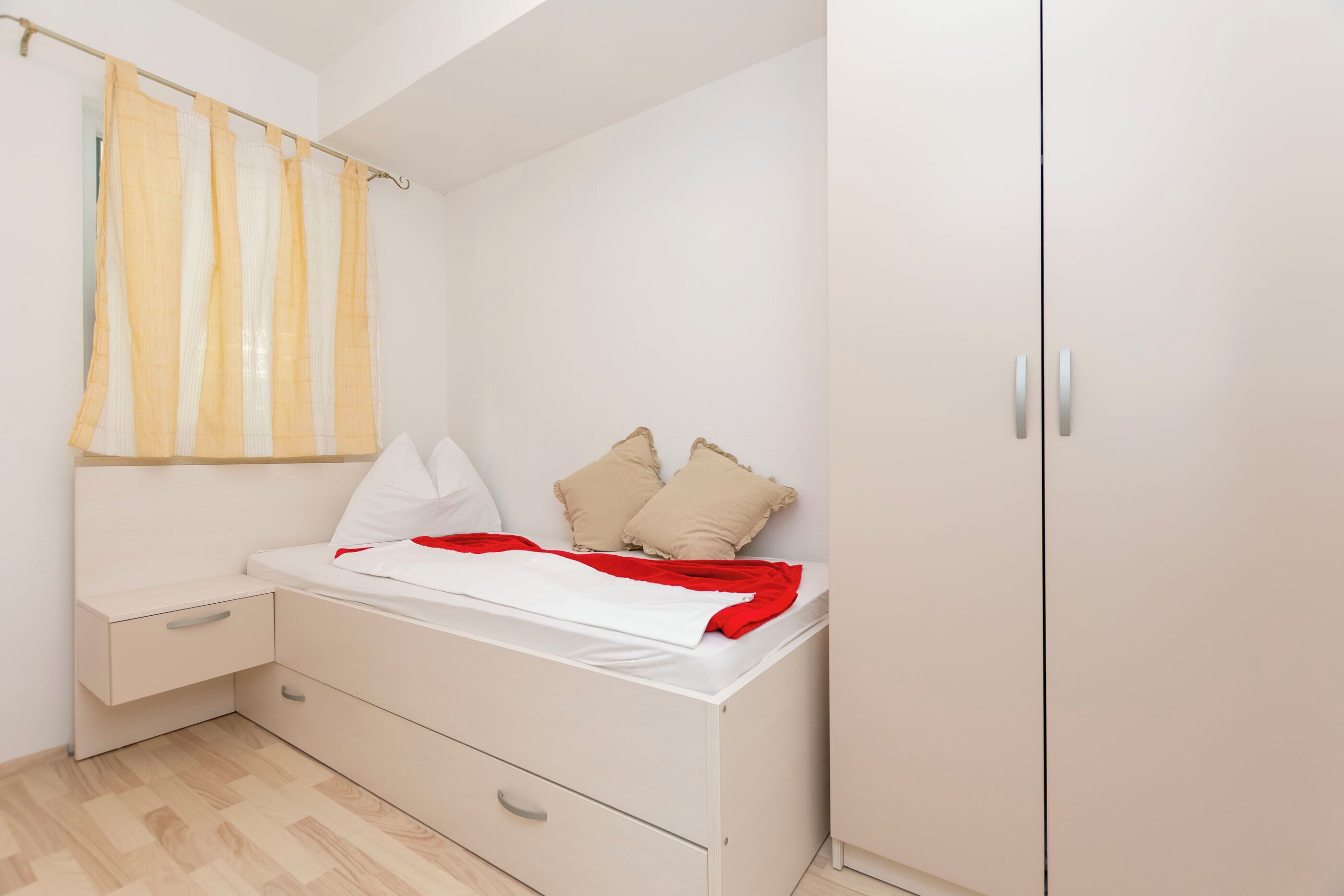 Un dormitorio con cama, mesita de noche, armario y cortina de ducha.