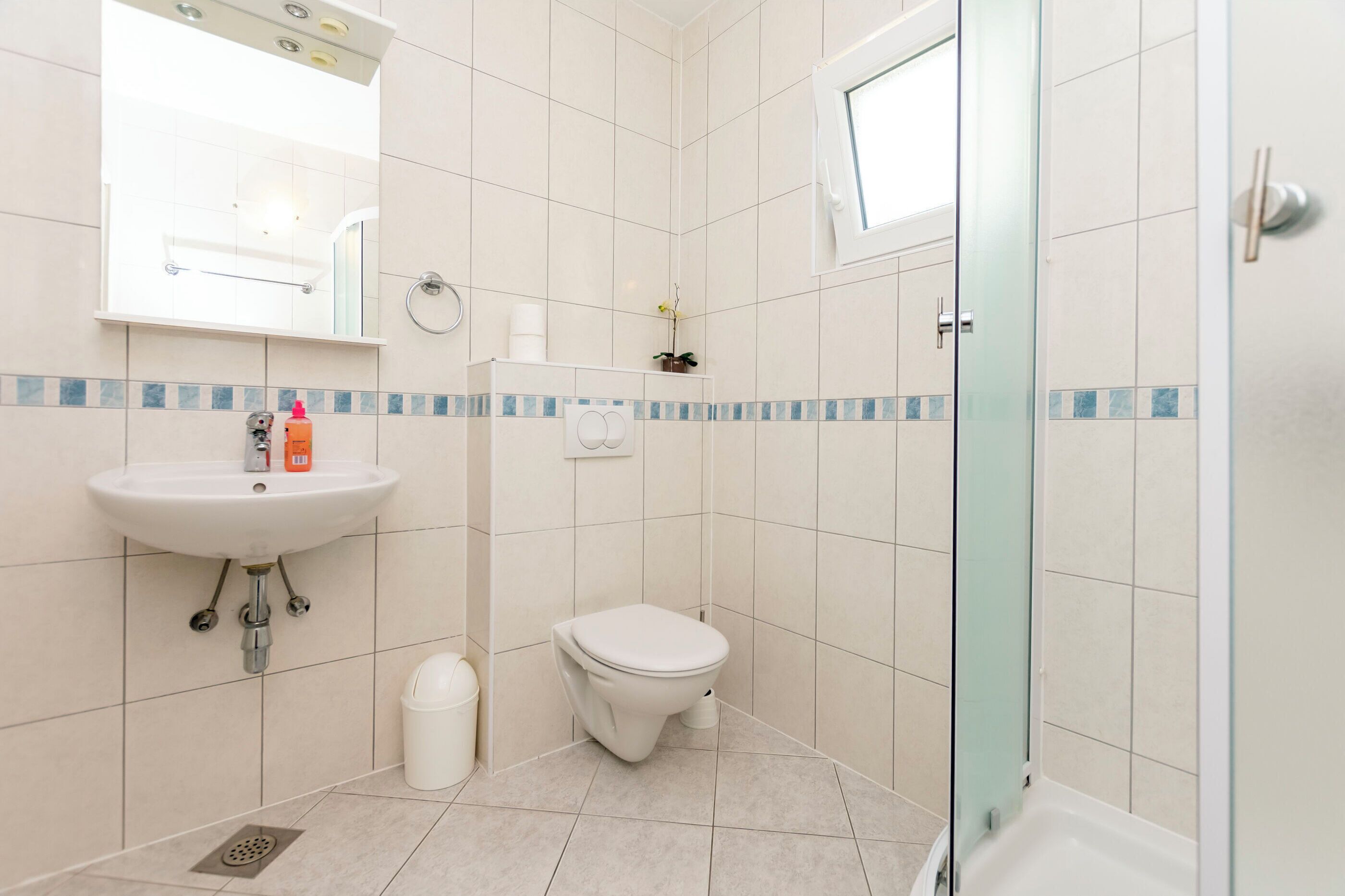A bathroom with a sink, toilet, and shower.