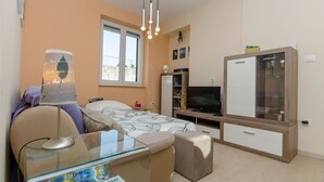 A modern bedroom with a bed, bedside table, and a TV. - Apartment City Light (Split)