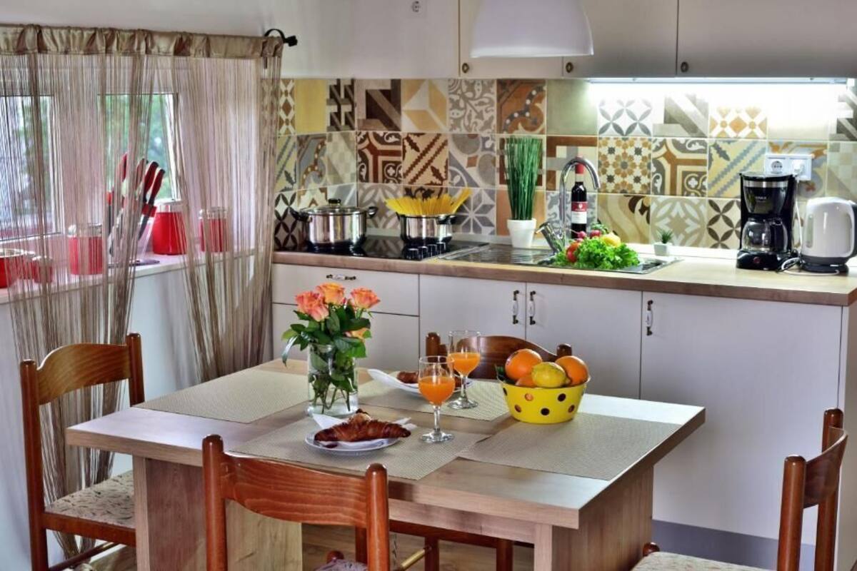 Una cucina con un tavolo da pranzo apparecchiato per la colazione, una macchina del caffè e diversi utensili da cucina.