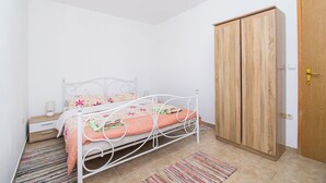 Egy hálószoba, amelyben található egy ágy, egy szekrény, egy éjjeliszemélyzet és egy lámpa.