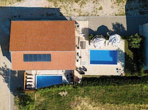 A rooftop with a swimming pool, a covered seating area, and a stone wall. - House Stone Curlew 5 (Benkovac)
