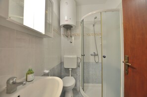 A bathroom with a sink, toilet, and shower. - Apartments Caterina (Pula)