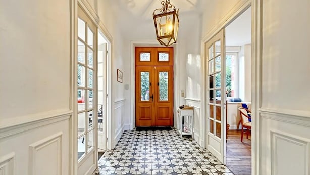 A hallway with a star-patterned floor, a wooden door with glass panels, and a hanging light fixture. - Renovated family home 14 sleeps 10 min from beaches, parking and wifi (Quéven)