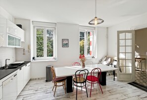 Una cocina moderna con armarios blancos, encimera negra y un amplio ventanal.