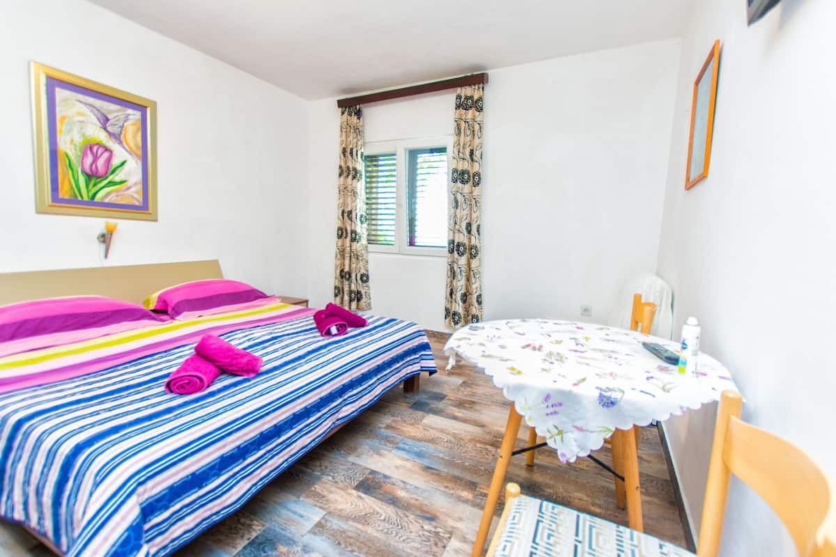Um quarto com uma cama, uma mesa e uma cadeira.