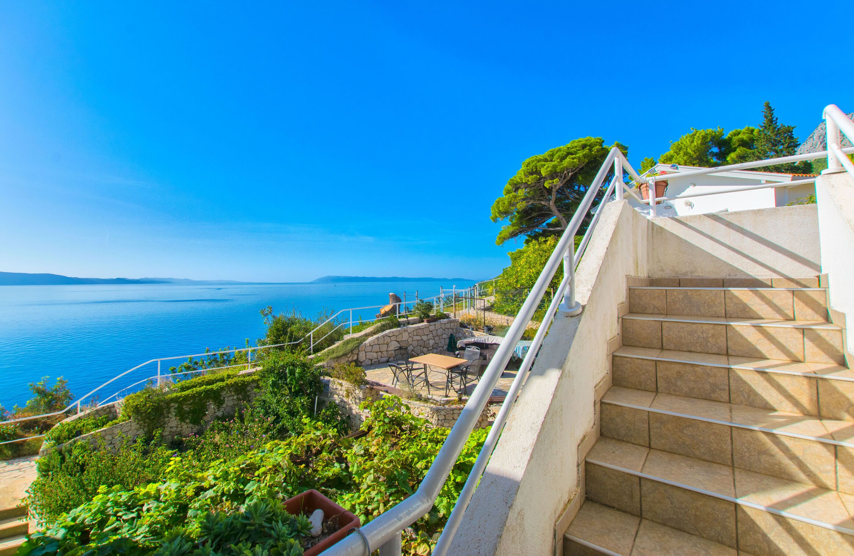 Una escalera conduce a una terraza con vistas al mar.