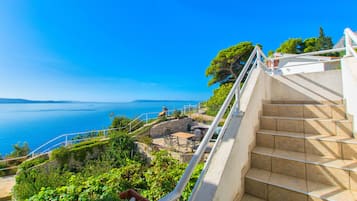 Una escalera conduce a una terraza con vistas al mar.