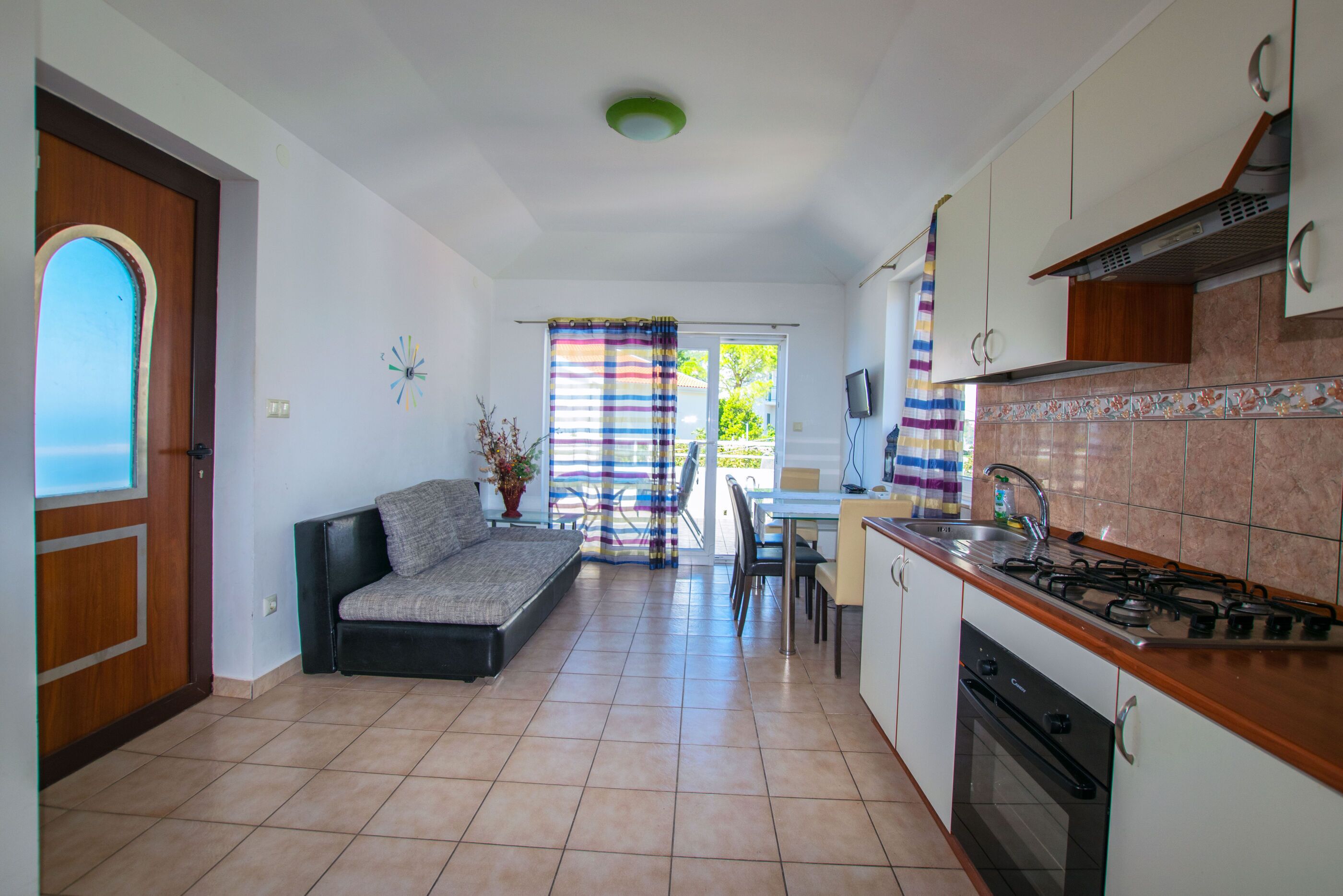 Una cocina compacta con comedor, un sofá y vistas por la ventana.