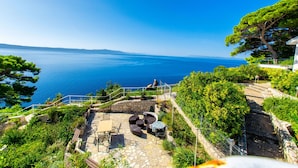 Un patio con mobili da esterno che si affaccia su una vista panoramica del mare.