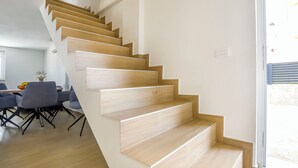 A modern staircase with wooden steps leading to a second floor. - House Sea Stone (Pasman)
