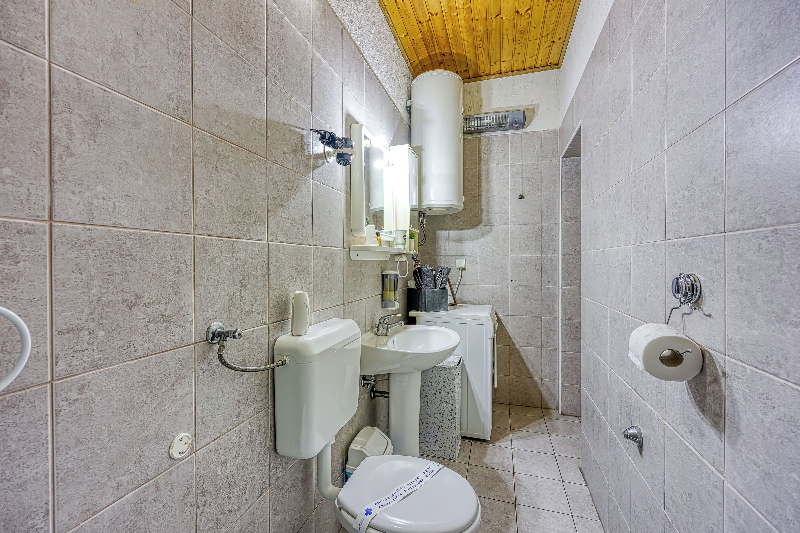 Ein kleines Badezimmer mit Toilette, Waschbecken und Dusche.