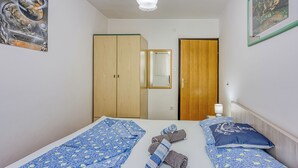 Una camera da letto con un letto, un armadio, uno specchio e un quadro appeso al muro.