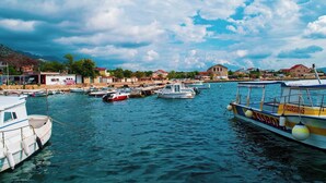 A marina with various boats docked, a pier, and buildings in the background. - Apartments and Room Adriana (Starigrad)