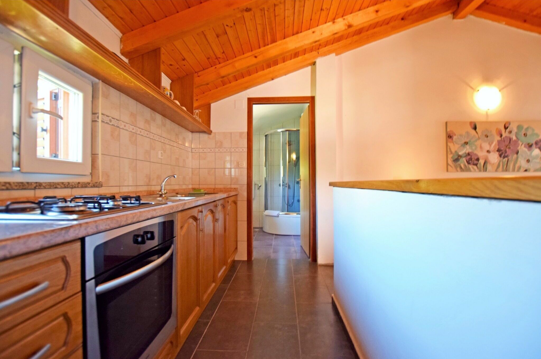 A kitchen with wooden cabinets, a stove, and a sink.