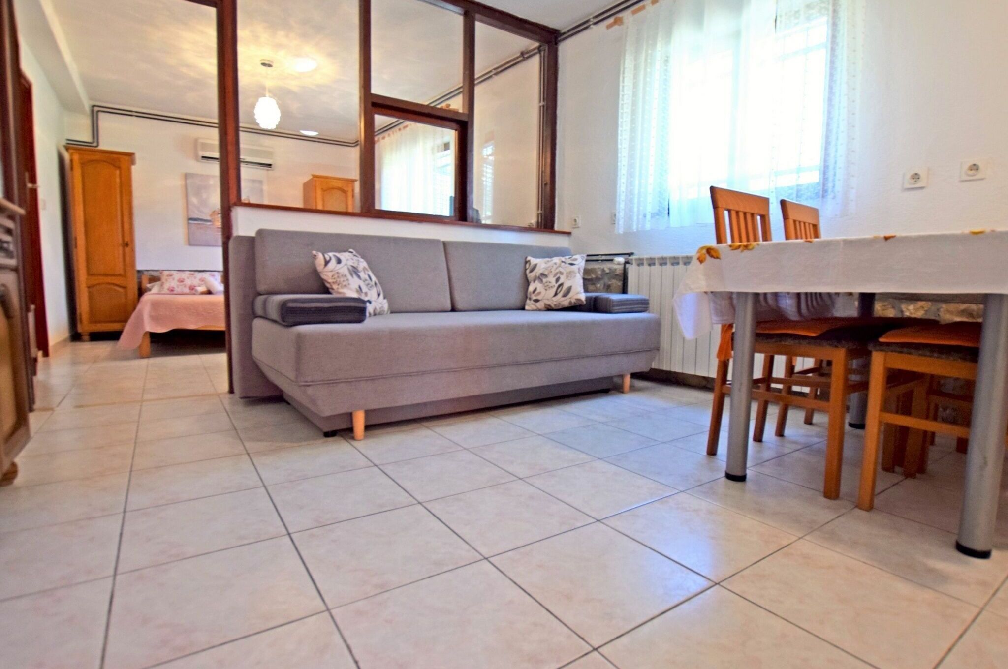 A living room with a sofa, a dining table, and chairs.