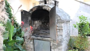 A stone structure with a door, surrounded by greenery. - Apartment Branka (Vodice)