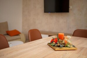 Une table à manger agrémentée d’un arrangement floral et d’une bougie.