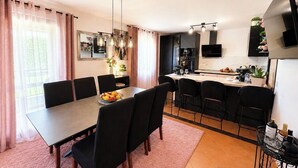 Een moderne keuken met een eethoek, een grote tafel en stoelen.
