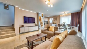 A modern living room with a sofa, coffee table, and a painting on the wall. - Villa Astrid (Rasa)