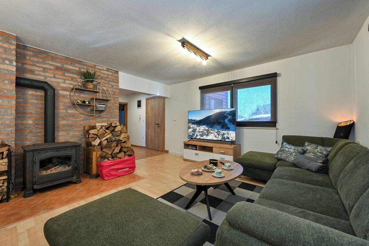 Ein Wohnzimmer mit Kamin, Fernseher und einer Couch.