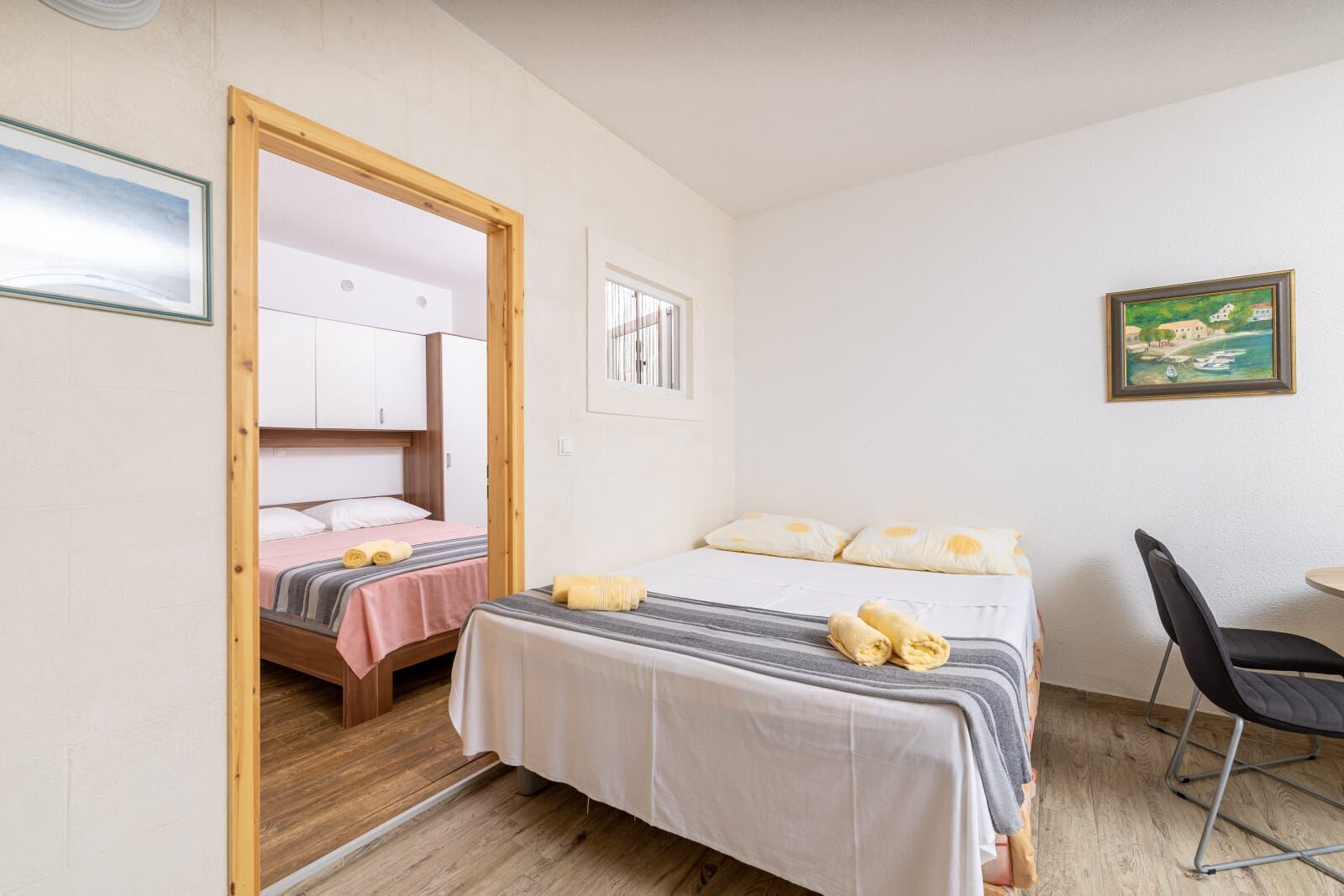 Una camera da letto con un letto, due comodini, una sedia e una porta che conduce al bagno.