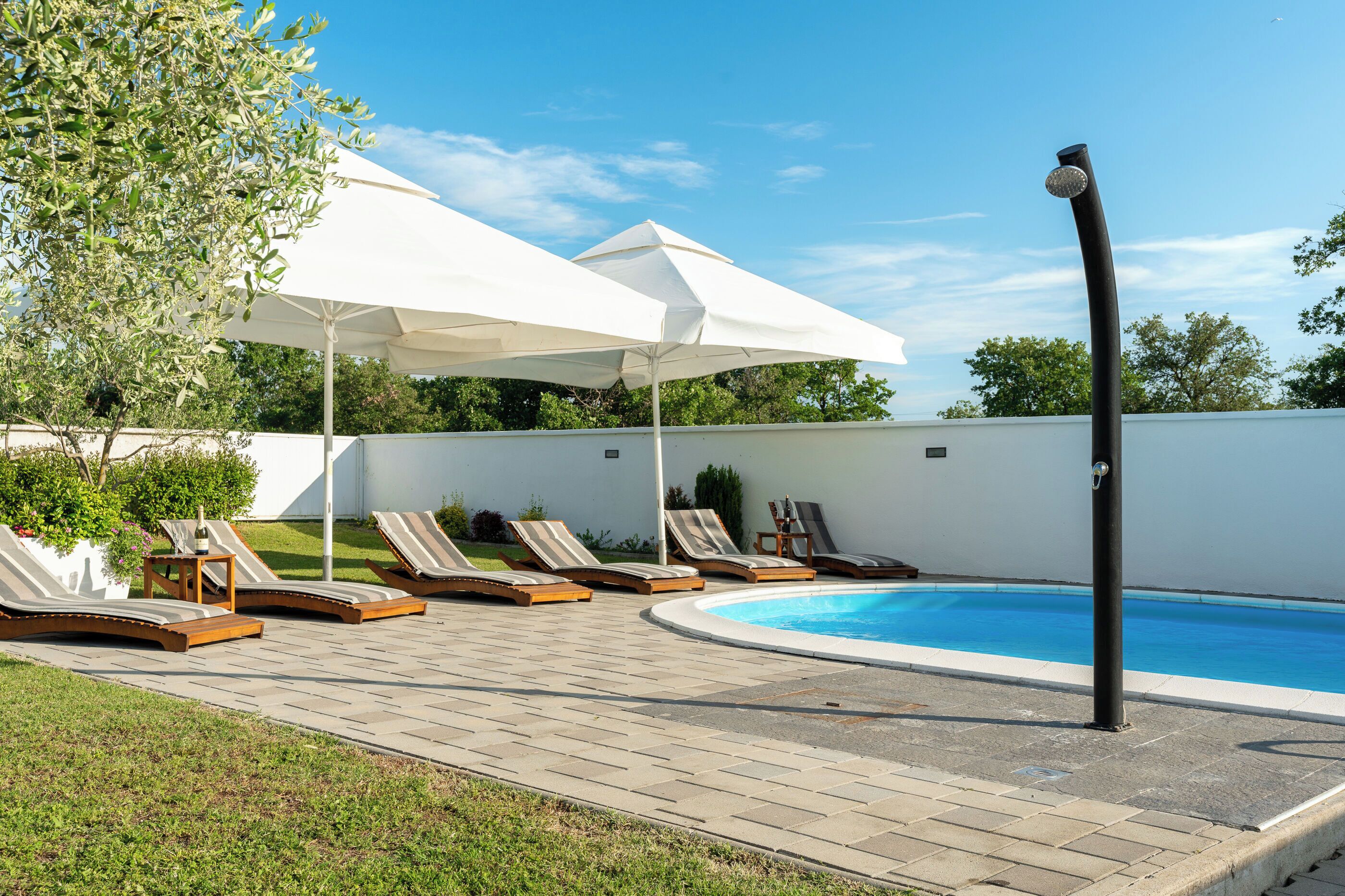 A poolside area with lounge chairs and umbrellas.