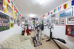 Ein Fitnessstudio mit Trainingsgeräten und Wänden, die mit Sportmemorabilien geschmückt sind.